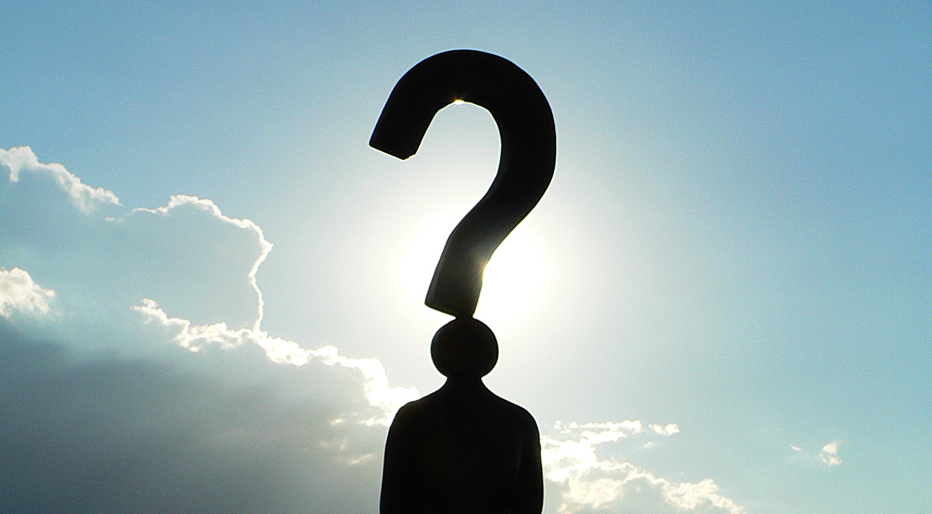 Question mark keyhole with sky behind it