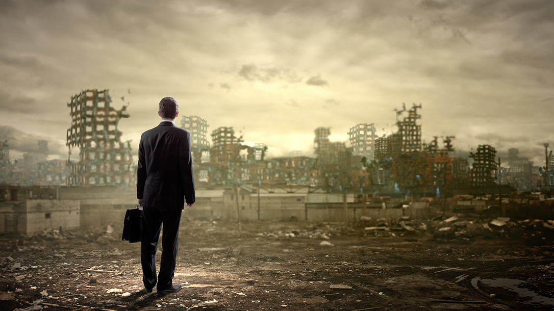 Business man looking over destroyed town