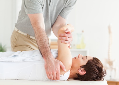Man stretching a woman's arm in a room