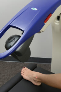 The M6 MLS Therapy Laser treating a woman's ankle.
