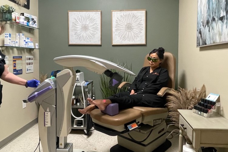 A patient receiving MLS Laser Therapy treatment on her ankle in Dr. Nathan Ivey's clinic.