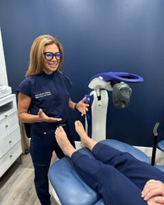 Dr. Souliotis standing next to her M6 MLS Therapy Laser while speaking to a patient.