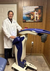 Dr. Waldman standing next to his M6 MLS Therapy Laser.