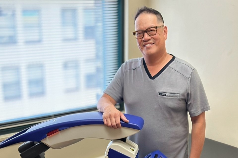 Dr. Chin standing next to his M6 MLS Therapy Laser