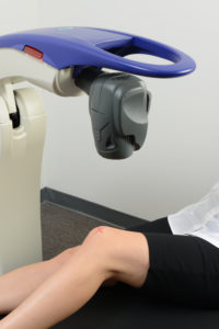 The Robotic M6 MLS Therapy Laser Treating a Woman's Knee