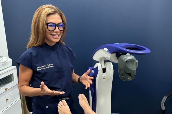 Dr. Souliotis standing next to her M6 MLS Therapy Laser